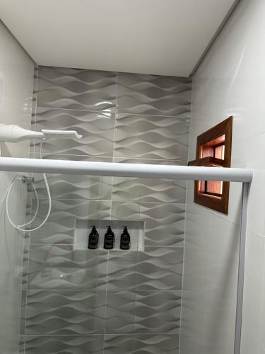 a bathroom with a shower with three black at Apartamento aconchegante em Irecê in Irecê
