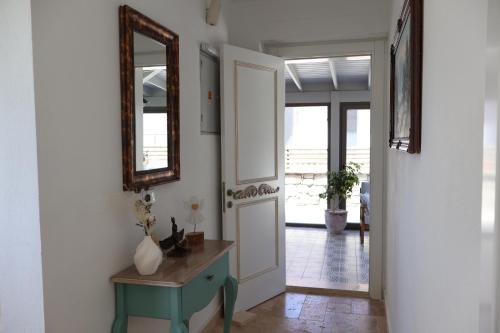 a hallway with a door and a mirror and a table at My Angels Alaçatı in Alaçatı