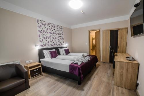 a bedroom with a bed and a chair and a couch at Az Idill in Cserszegtomaj