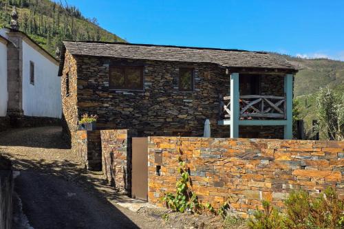 a stone house with a brick wall and a gate at Casa da Figueira - Rio Paiva in Arouca