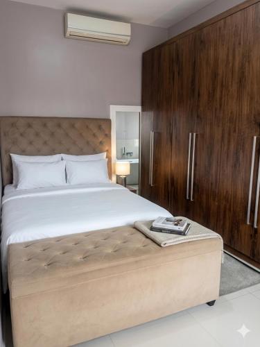 a bedroom with a large bed and wooden cabinets at Refúgio Urbano Amplo e Luxuoso in Imperatriz