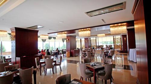 a restaurant with tables and chairs and people sitting at tables at Tilya Resort Hotel in Trabzon