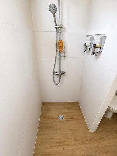 a white bathroom with a shower and a toilet at Au Petit Bungalow - Air conditionned & Mountain view in Moorea