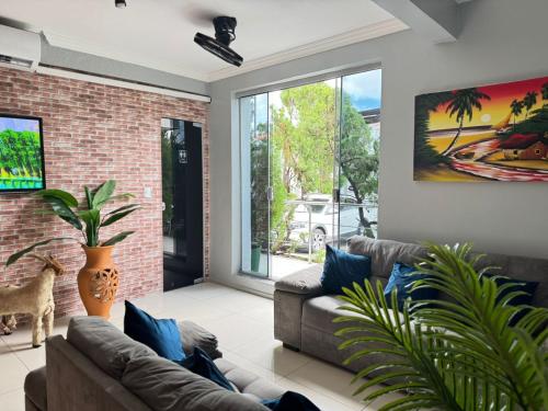 a living room with a couch and a large window at Hotel Aeroporto Star in Fortaleza