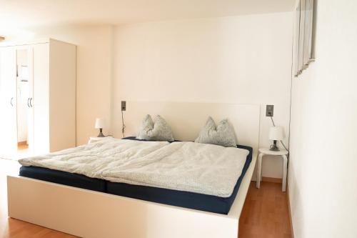 a white bedroom with a large bed in a room at Ufer Nest in Buochs in Buochs