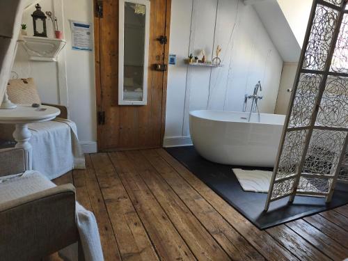 a bathroom with a white tub and a sink at Chambres d'hôtes Atypik in Dieppe