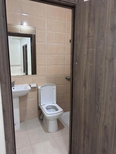 a bathroom with a toilet and a sink and a mirror at Rmilate Coast Apartment in Asilah