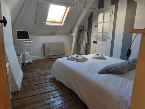 a bedroom with a white bed and a window at Chambres d'hôtes Atypik in Dieppe