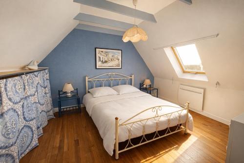a bedroom with a bed and a blue wall at Ty Mimi in Plozévet