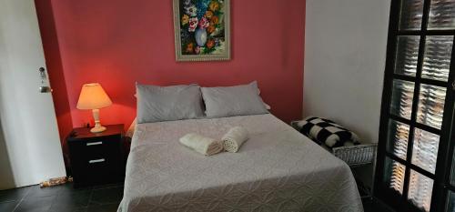 a bedroom with a bed with two towels on it at Hostel Yellow House MG in Itamonte