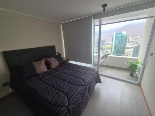 a bedroom with a bed and a large window at Studio Distrito Cavancha 2 in Iquique