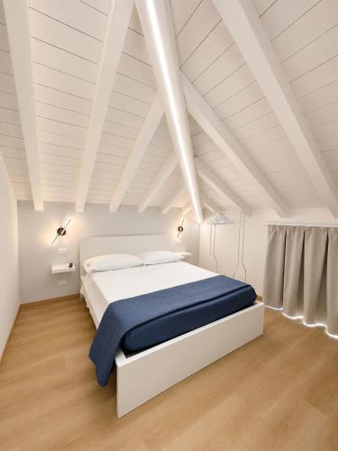 ein Schlafzimmer mit einem weißen Bett und einer blauen Decke in der Unterkunft Sebì Suite in Iseo