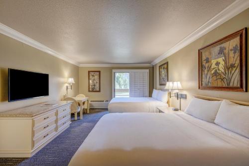 a hotel room with two beds and a flat screen tv at Indian Wells Resort Hotel in Indian Wells