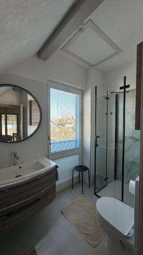 a bathroom with a tub and a sink and a mirror at Ferienhaus Sandbrise in Zingst