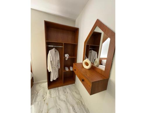 a bathroom with a mirror and a wooden cabinet at Hermes On The Spot Pyramids Hotel in Cairo