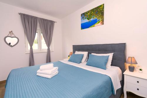 a bedroom with a blue and white bed and a window at Villa Olivarum in Stankovci