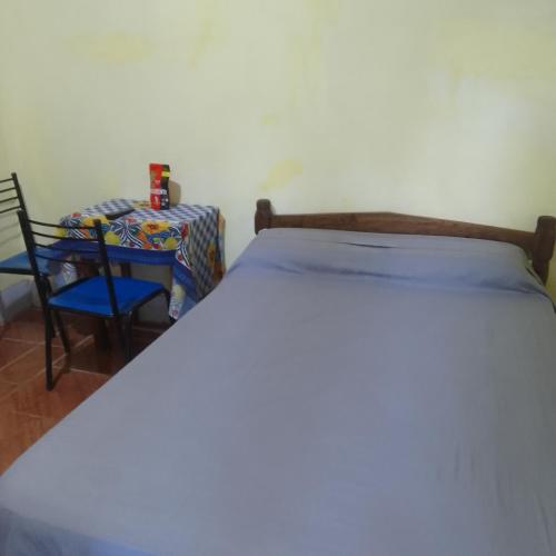 a bedroom with a bed and a table and a chair at Hospedaje jabuticaba in El Soberbio