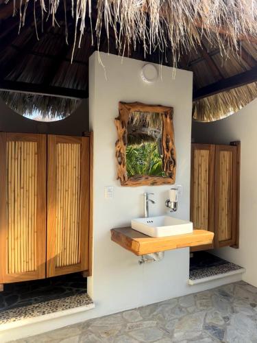 a bathroom with a sink and a mirror at Casa Mario Alberto - Oceanfront Bungalows in Puerto Ángel