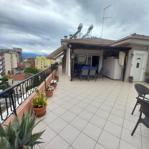 a balcony with chairs and tables on a house at Evi's balcony in Karditsa
