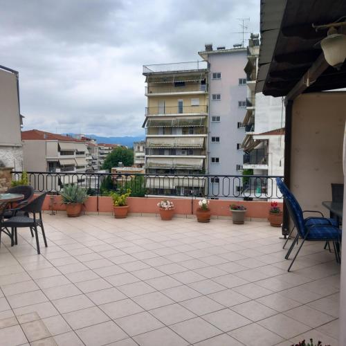 a balcony with chairs and tables and buildings at Evi's balcony in Karditsa