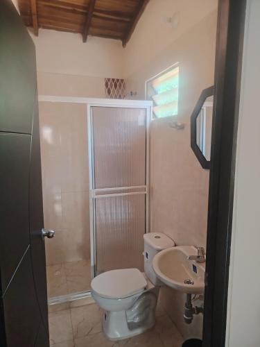 a bathroom with a toilet and a sink at Hostal El Renacer in Pinchote