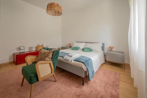 a white bedroom with a bed and a chair at Villa Eremo Cinque Terre in Castiglione Chiavarese