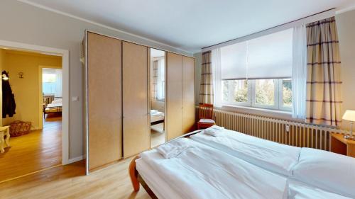 a bedroom with a bed and a large window at Landhaus Gerdts - 5 in Cuxhaven
