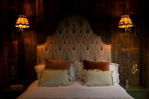 a bedroom with a large bed with two lights on it at Clover in Wrenbury