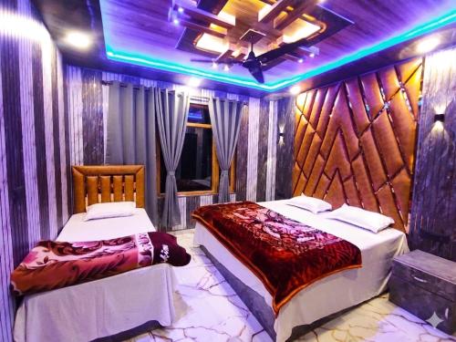 two beds in a room with purple lights at HOTEL FABULOUS KASHMIR, Dal lake in Srinagar