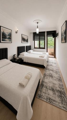 ein Schlafzimmer mit drei Betten und einem Teppich in der Unterkunft Luxury Monastery Apart & Hotel in Trabzon
