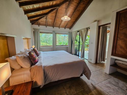 a bedroom with a large bed in a room with windows at Hotel Argovia Centro Wellness in Tapachula