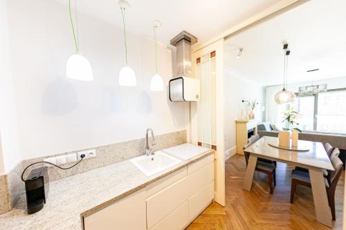 a kitchen with a sink and a dining table at House of Zen - Apartament z widokiem na Motławę i Stare Miasto in Gdańsk