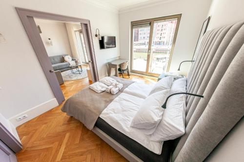 a large bed in a room with a large window at House of Zen - Apartament z widokiem na Motławę i Stare Miasto in Gdańsk