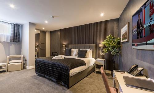 a bedroom with a bed and a desk with a phone at Hotel 30 Five in Aberdeen