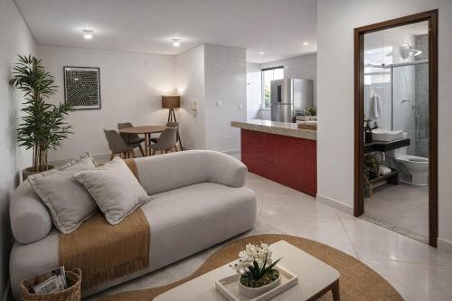 a living room with a couch and a kitchen at Super Apt morada do Vale in Governador Valadares