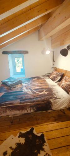 a large bed in a room with wooden floors at Il borghetto di Lele & Schina in Arvier