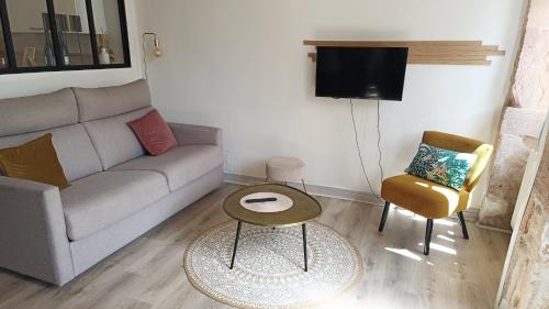 a living room with a couch and a table and chairs at Le gîte de Varanges in Givry