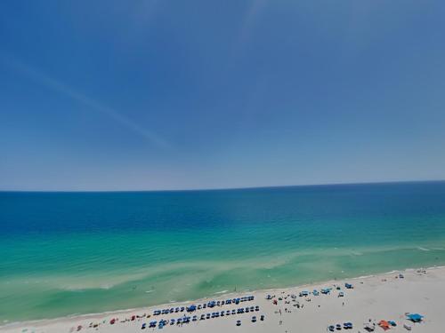 a beach with many umbrellas and the ocean at The Oasis Orange Beach 2110 in Orange Beach
