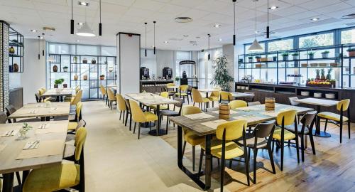 a restaurant with tables and chairs and a bar at Sercotel Madrid Aeropuerto in Madrid