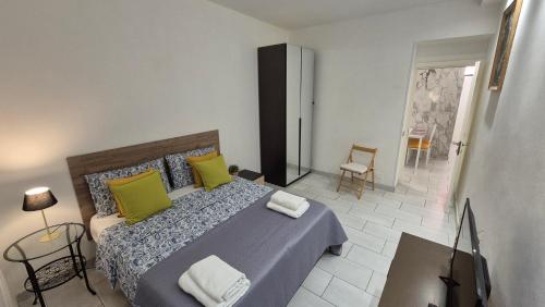 a bedroom with a bed with green and yellow pillows at Ladispoli Apartment in Ladispoli