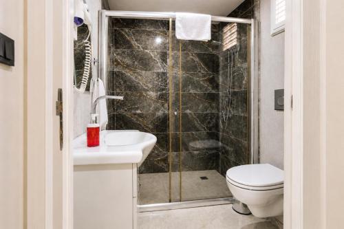 a bathroom with a shower and a toilet and a sink at Fii Suites in Kumluca