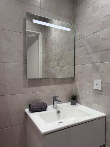 a bathroom with a white sink and a mirror at Duplex T2 cosy - Hyper Centre - Parking privé in Bourges