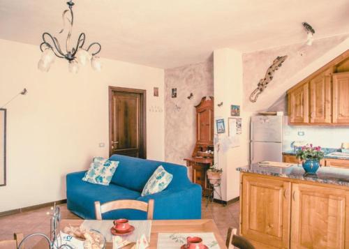 a living room with a blue couch and a kitchen at Via della Musica in Vicchio