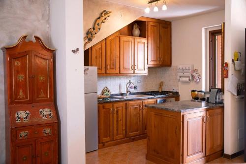 a kitchen with wooden cabinets and a sink and a refrigerator at Via della Musica in Vicchio