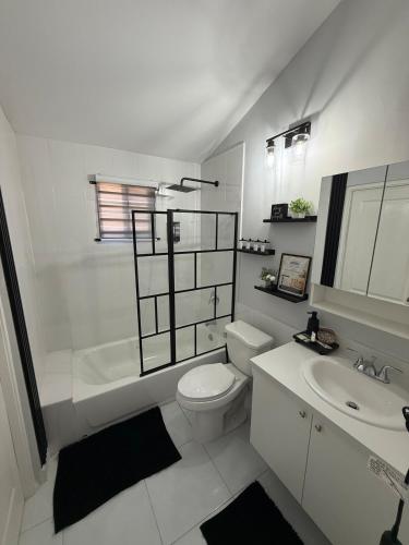 a white bathroom with a toilet and a sink at The Perrys Chateau in Old Harbour