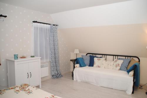 1 dormitorio con 1 cama blanca y vestidor blanco en Erdőszéli Házikó Vendégház, en Bükkszék