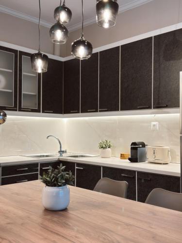 a kitchen with black cabinets and a wooden table at Stay Central 2 in Ioannina