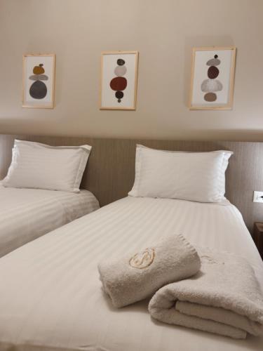 a white bed with a towel on top of it at Stay Central 2 in Ioannina
