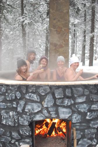 a group of people in a bath tub next to a fireplace at Zelena Dacha in Dragobrat