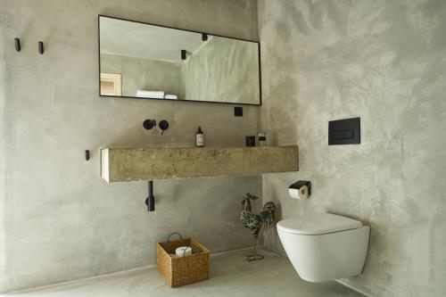 a bathroom with a sink and a toilet and a mirror at Riverside Lodges - Serra da Estrela - Chão da Ribeira in Gouveia
